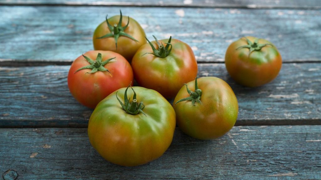 Tomates verdes sobre mesa de madera